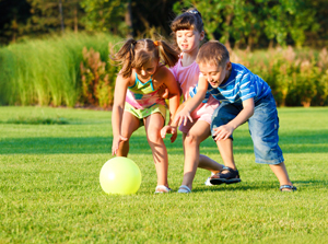 kids playing with ball on summer lawn